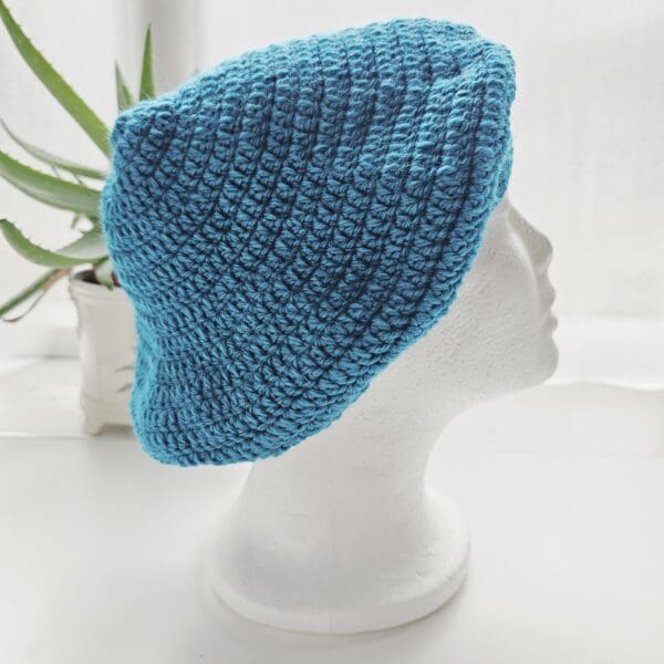 Detailed shot of the stitch pattern on a Sea Blue crochet beret. The texture of the aran yarn is clearly visible, showing the even tension and construction of the handmade hat.
