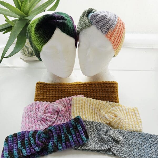 A cream-coloured crochet ear warmer with black flecks, made from aran yarn, is displayed on a white mannequin head. The ear warmer is shown in a photo collage from multiple angles.