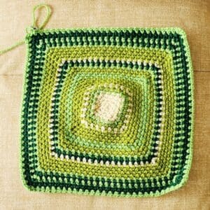 October temperature blanket square in rows of greens and some yellows.