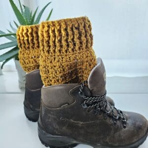 Crochet boot cuffs in Honeysuckle yellow aran yarn, visible above the tops of a pair of brown leather hiking boots.