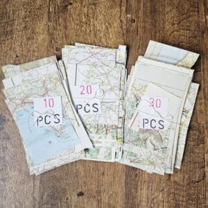 Map paper scraps shown in tied bundles of 10, 20 or 30 pieces put together by Sarah Lou Crafts.