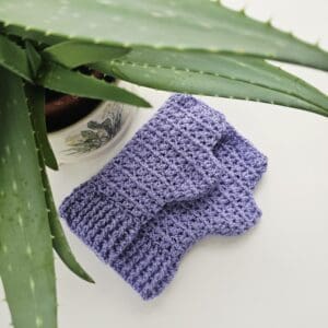 Detail shot of the cuff of a single lilac crochet mitt, focusing on the neat, rib border and the delicate colour of the yarn.