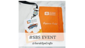 An orange notebook and a business lanyard featuring the #SBS Small Business Sunday logo and Resilience Rocks branding, laid out as a professional workspace header.