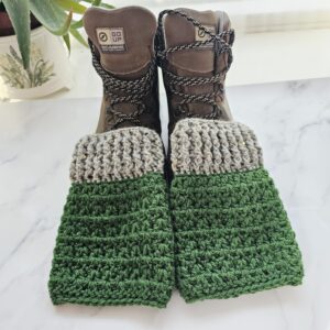 The two-tone green crochet boot cuffs add a cosy, handmade layer of warmth, contrasting with the rugged texture of the leather and laces.