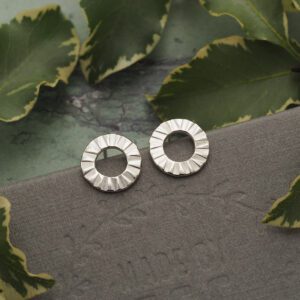 Sterling silver open circle stud earrings with faceted sunburst texture, front-facing design